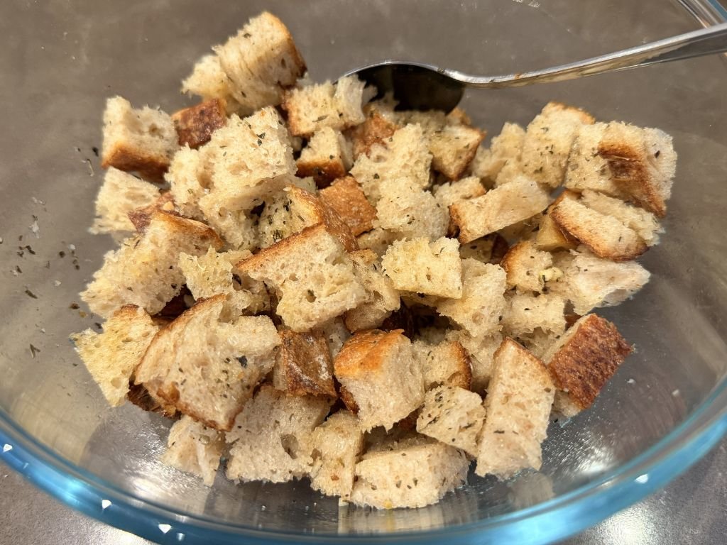 olijfolie-en-kruiden-toevoegen-aan-croutons olijfolie en kruiden toevoegen aan croutons