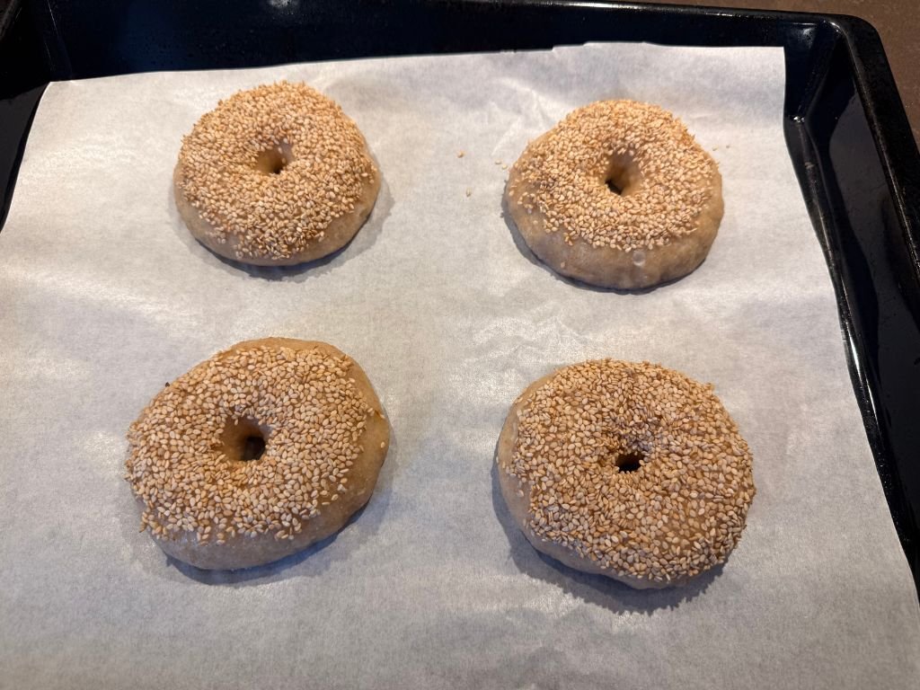 gekookte-zuurdesem-bagels gekookt zuurdesem bagel met topping klaar voor de oven